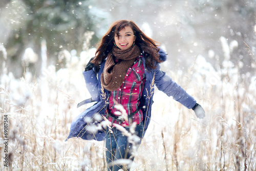 Girl having fun and jumping in the snow
