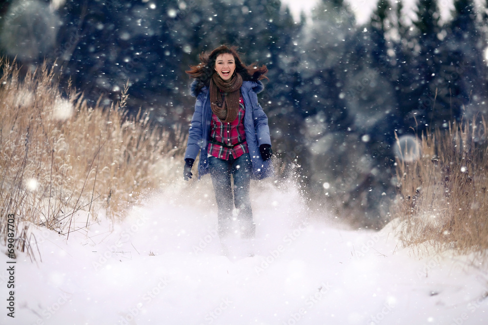 brunette girl running in a snowy forest brunette girl running in a snowy forest