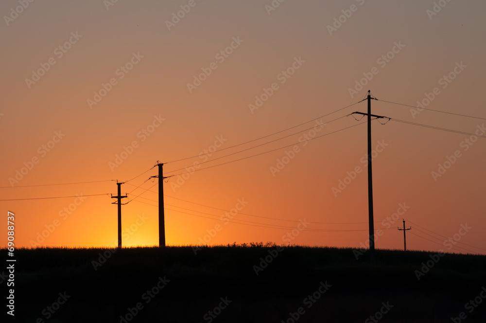 Orange, yellow sunset and four electric pylons