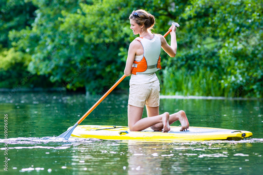 Fotografie Frau beim Stehpaddeln Sup auf Fluss