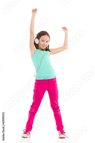 Little girl with headphones dancing with arms raised