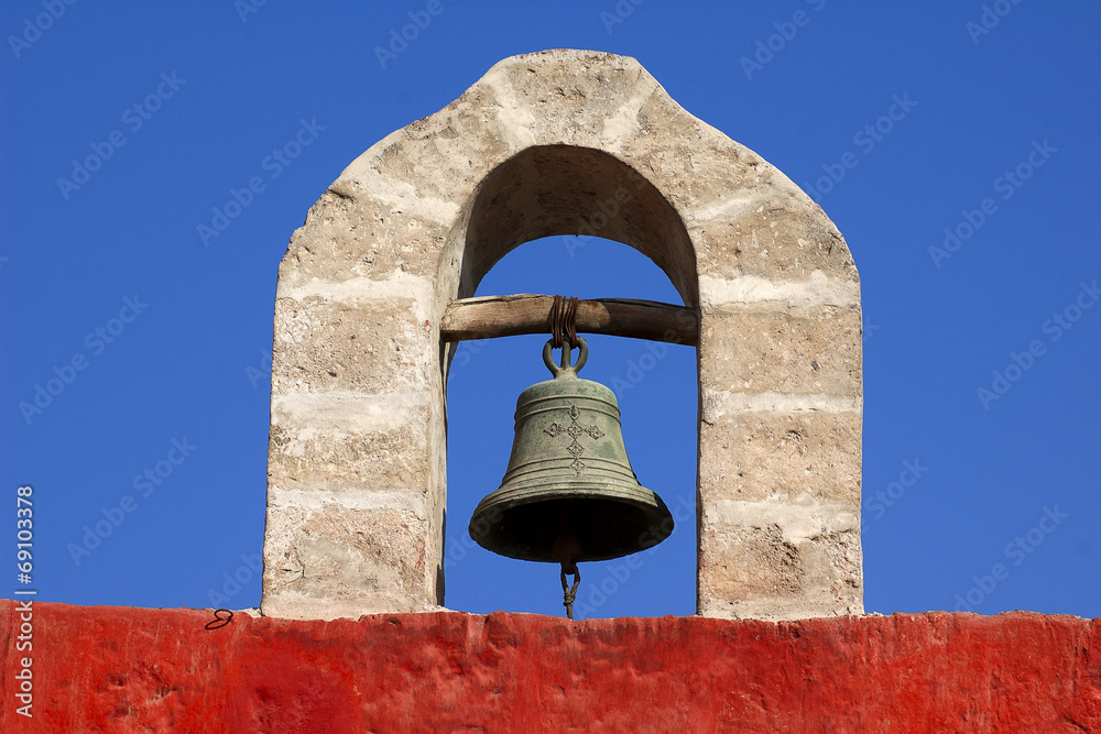 An ancient bell hanging on the stone arch