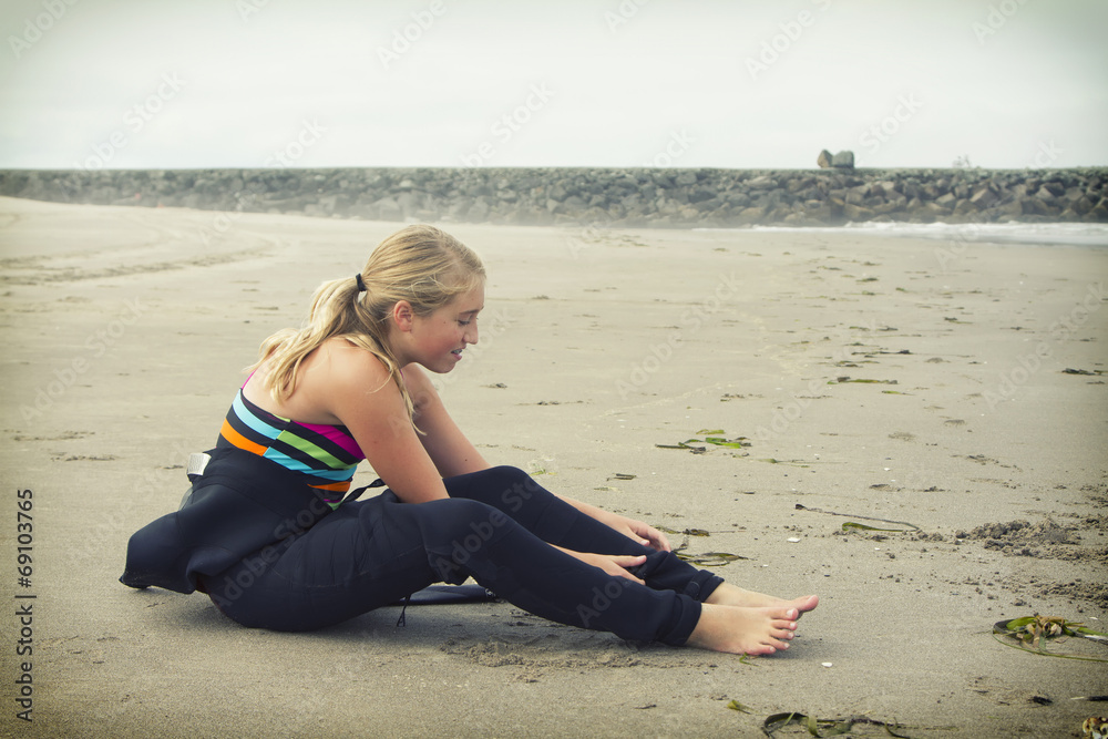 Teen girl putting on a wetsuit at Rockaway Oregon Teen girl putting on a wetsuit at Rockaway Oregon