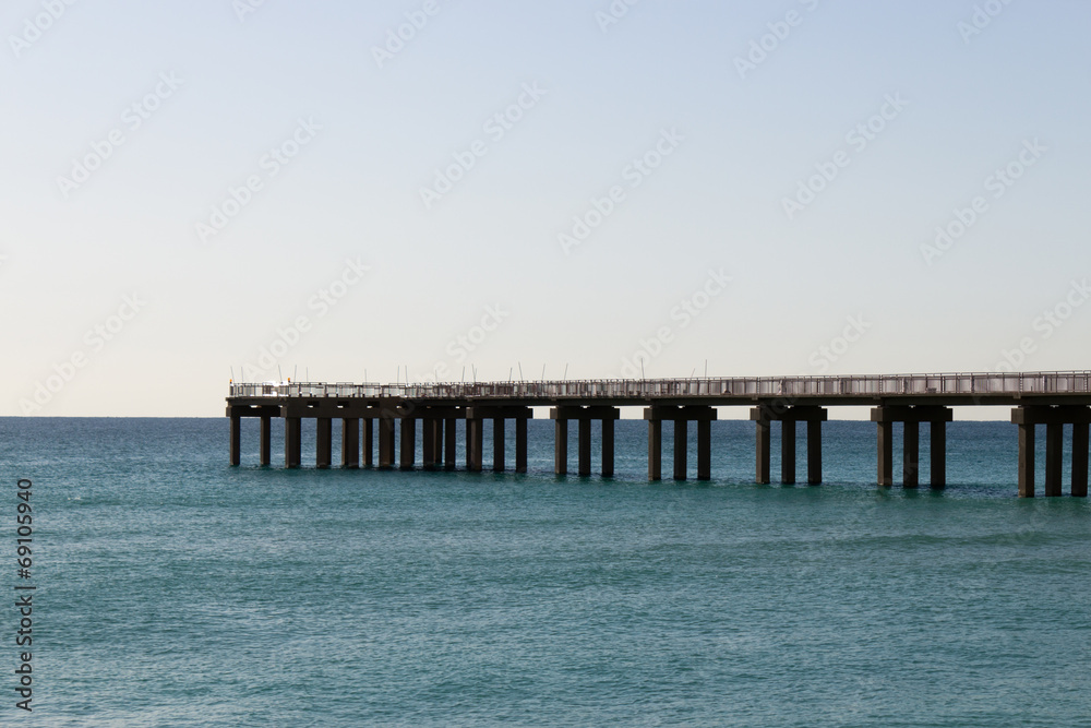 Ocean fishing pier stretchs over calm seas