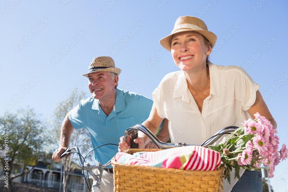 Happy senior couple going for a bike ride in the city