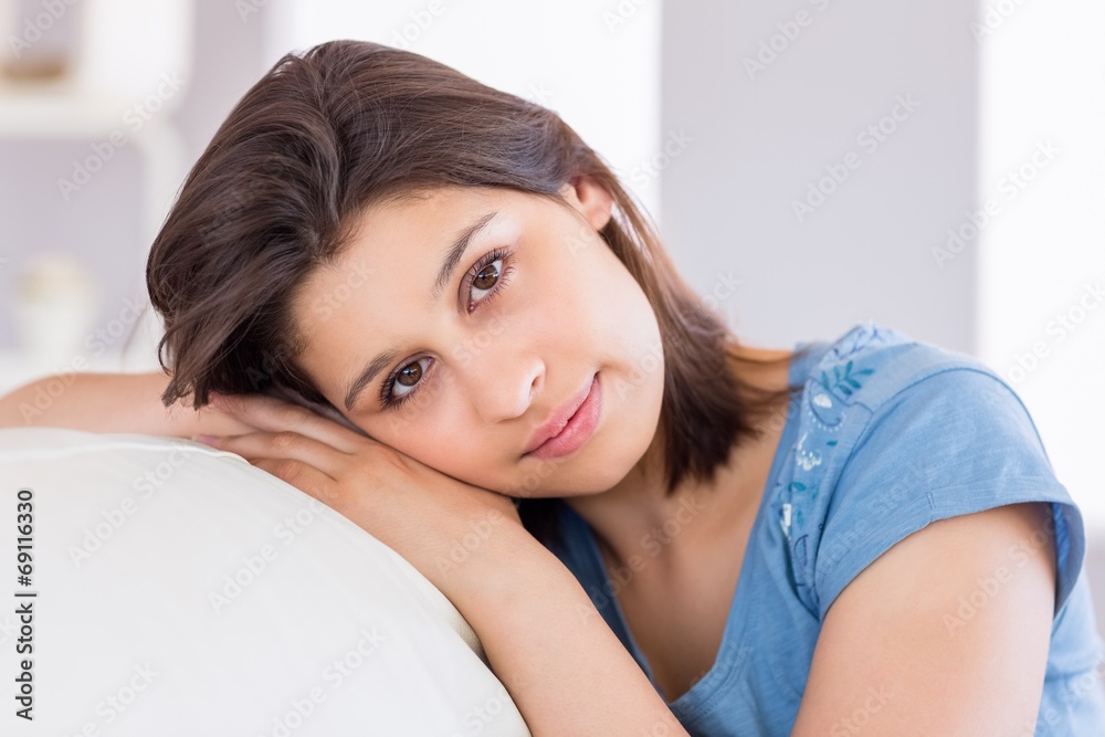 Pretty brunette smiling at camera on the couch Pretty brunette smiling at camera on the couch