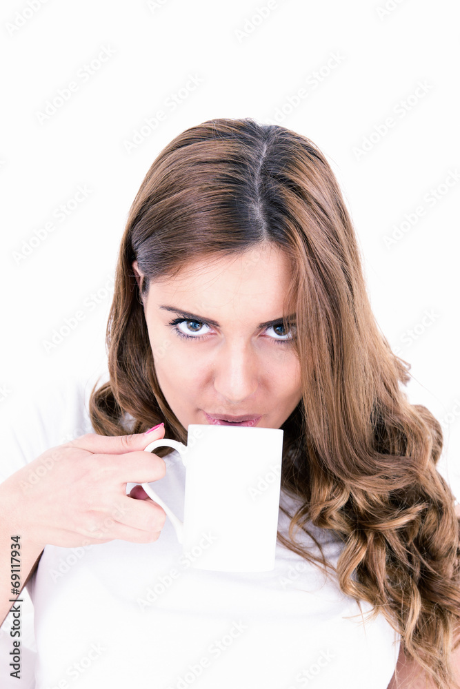 Content attractive brunette drinking from a cup in bright bedroo Content attractive brunette drinking from a cup in bright bedroo