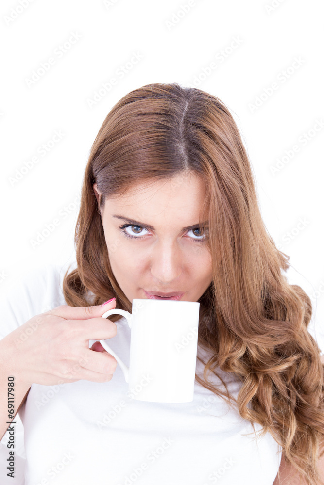 Content attractive brunette drinking from a cup in bright bedroo Content attractive brunette drinking from a cup in bright bedroo
