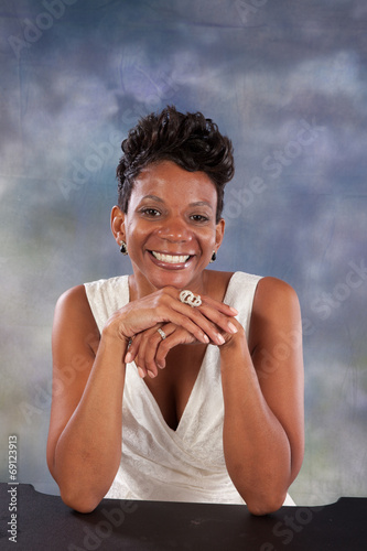 Black woman smiling with her hand under her chin