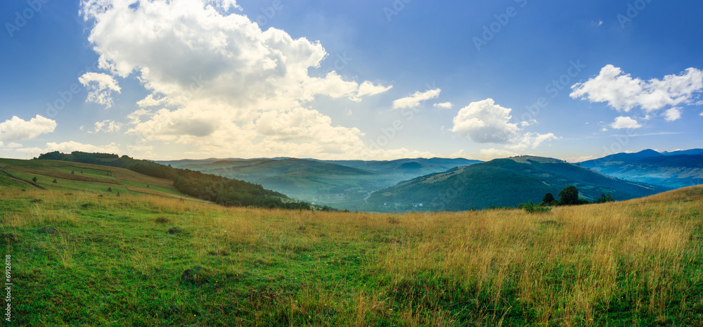 valley in mountains  on hillside under sky with clouds at sunsri