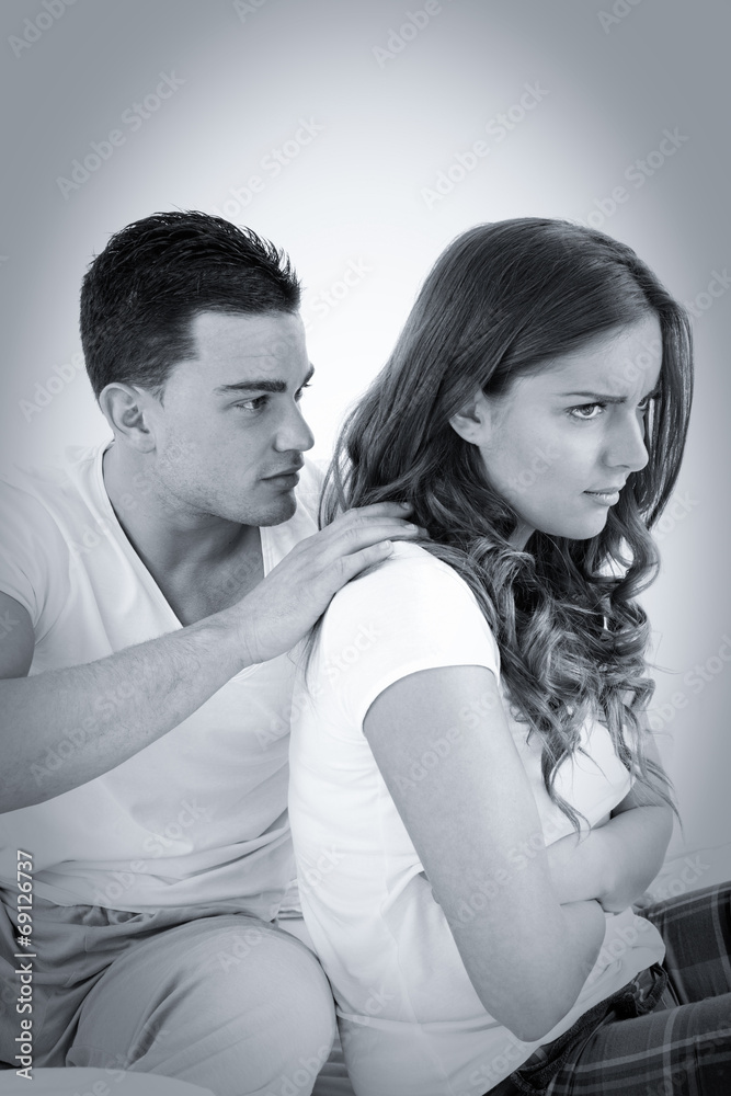 young woman ignoring her man partner in her bed during a conflic young woman ignoring her man partner in her bed during a conflic