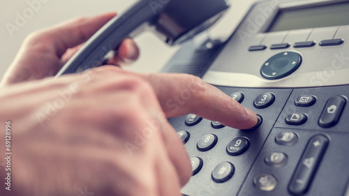 Man dialling out on a landline telephone photo