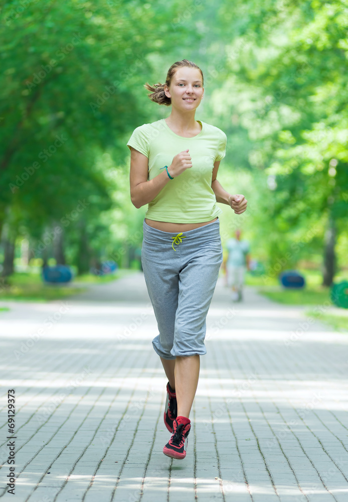 Woman jogging in city street park. Woman jogging in city street park.
