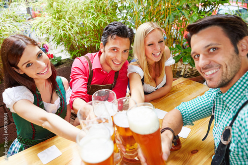 Freunde in Bayern im Biergarten prosten sich zu