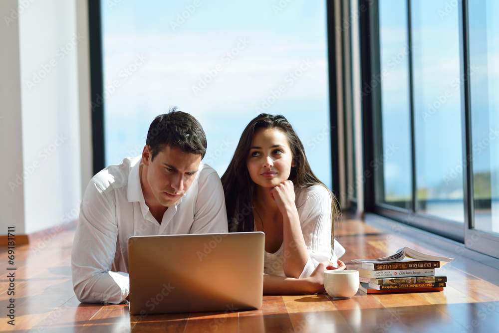 relaxed young couple working on laptop computer at home relaxed young couple working on laptop computer at home