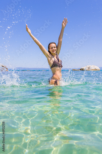 young woman in the sea splashing water