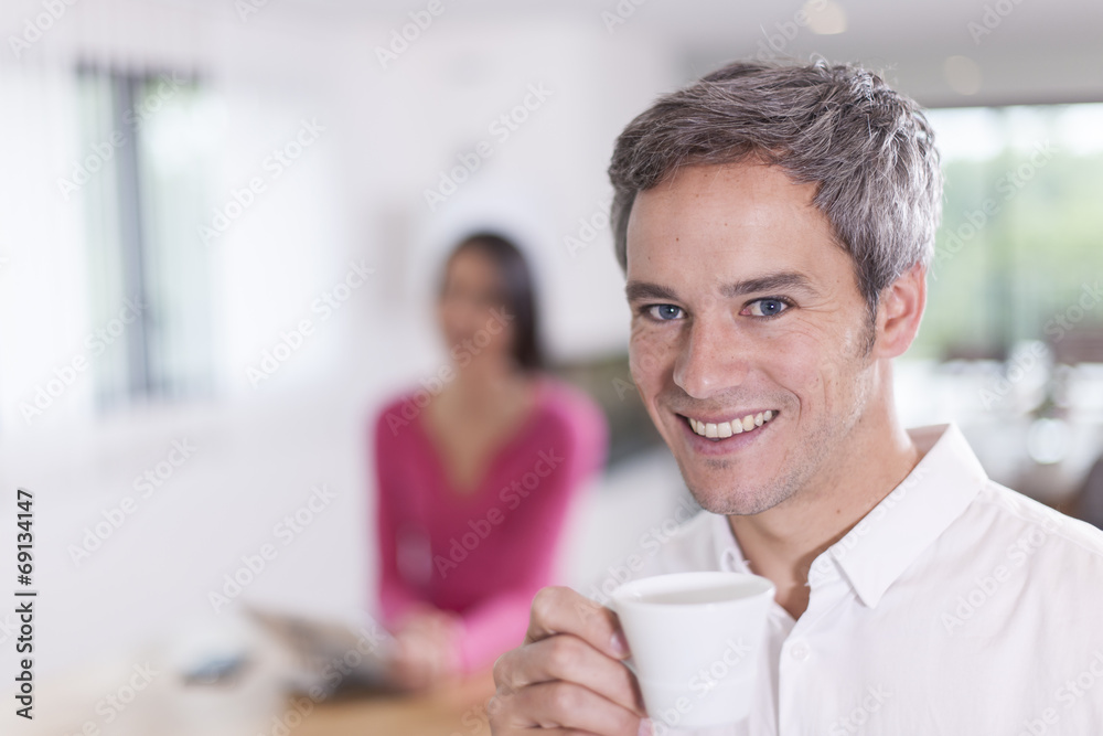 couple at home man at foreground drinking coffee