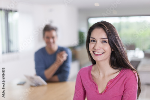 couple at home woman at foreground looking at camera