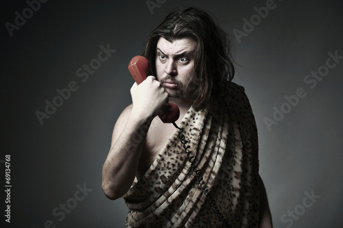 Wildman in leopard skin use retro telephone