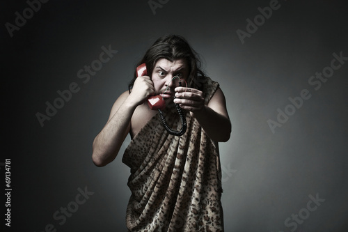 Wildman in leopard skin use retro telephone