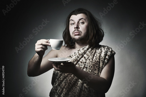 Savage man in skin of beast drink tea or coffee