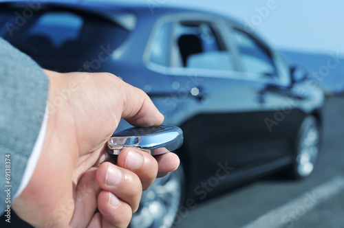 man in suit opening his car with the control remote key photo