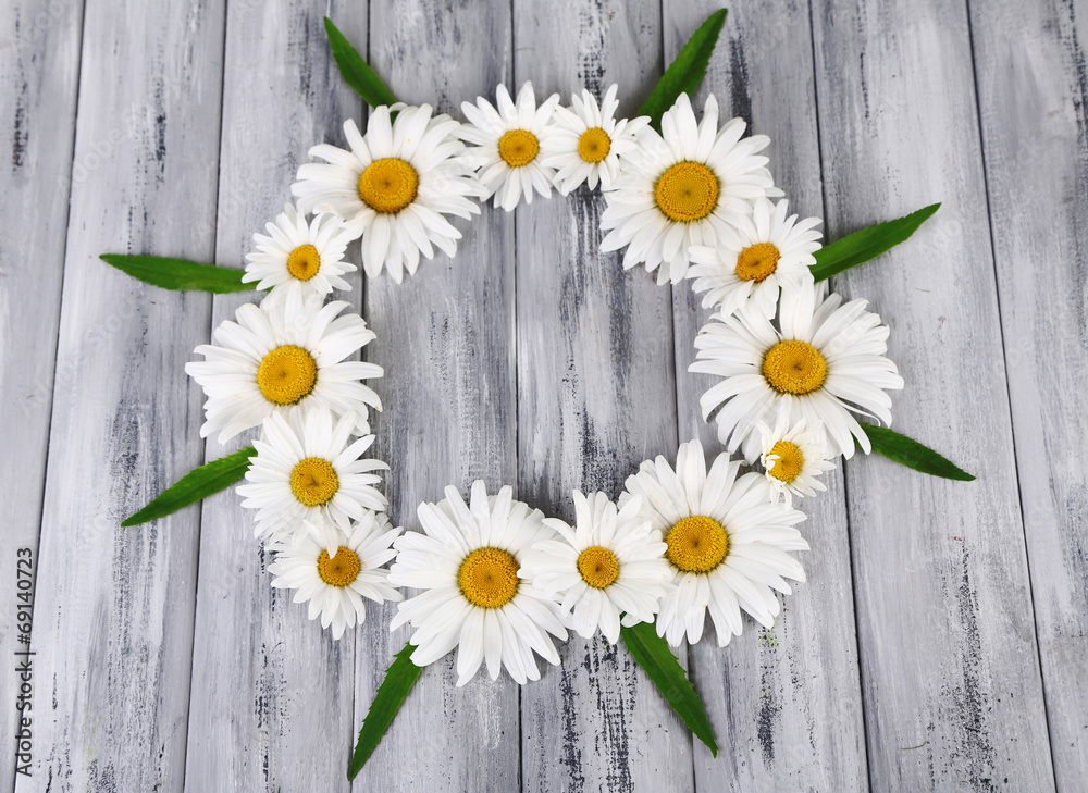 Obraz premium Chamomile wreath on grey wooden background