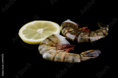 Fresh tasty prawns with lemon and dill on black background