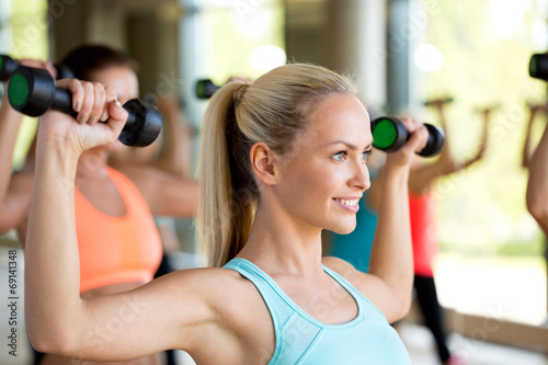 group of women with dumbbells in gym