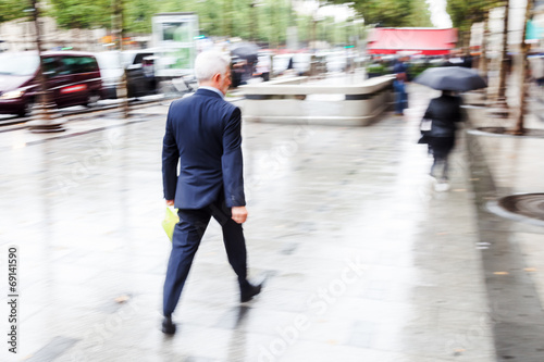 Geschäftsmann in Bewegungsunschärfe geht in der Stadt © Christian Müller