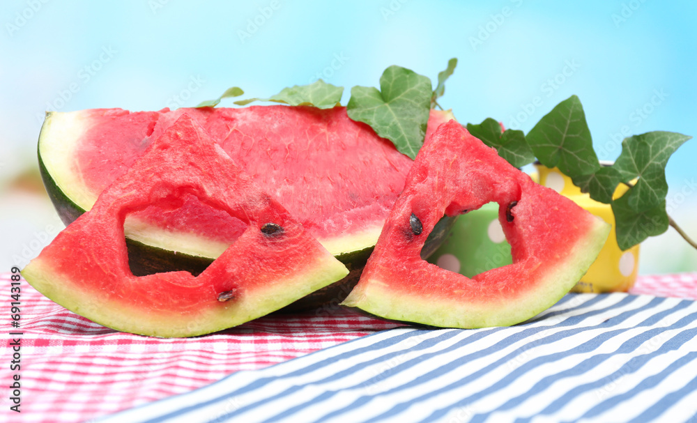 Fresh slices of watermelon on table, on blue background Fresh slices of watermelon on table, on blue background