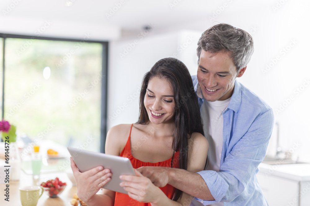 cheerful couple at home using digital tablet cheerful couple at home using digital tablet