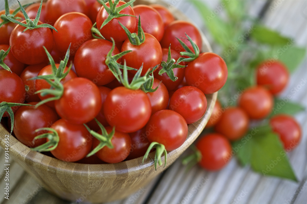 Cherry tomatoes in a wooden bowl.