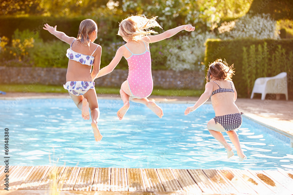 Group Of Girls Jumping Into Outdoor Swimming Pool - obrazy, fototapety, plakaty 