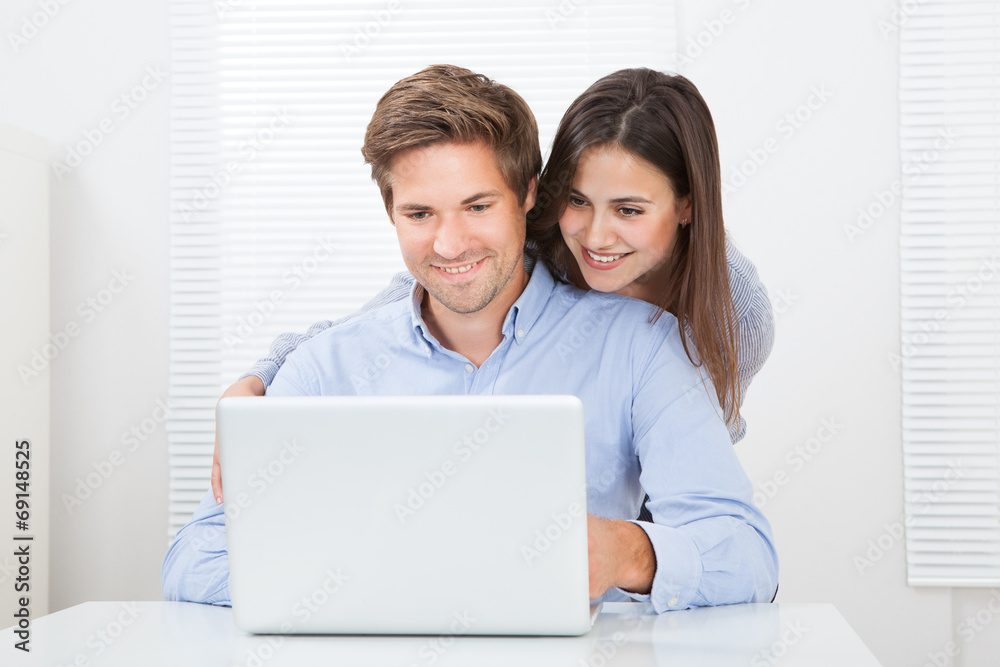 Surprised Man Looking At Woman While Using Laptop Surprised Man Looking At Woman While Using Laptop
