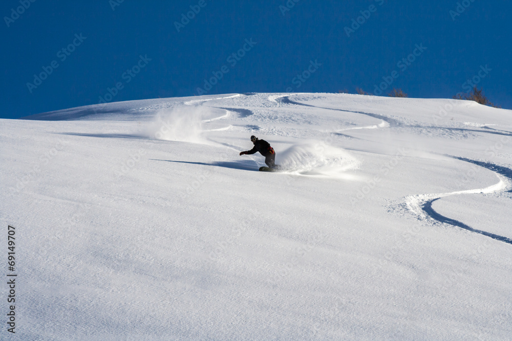 Snowboarder go down on powder snow.