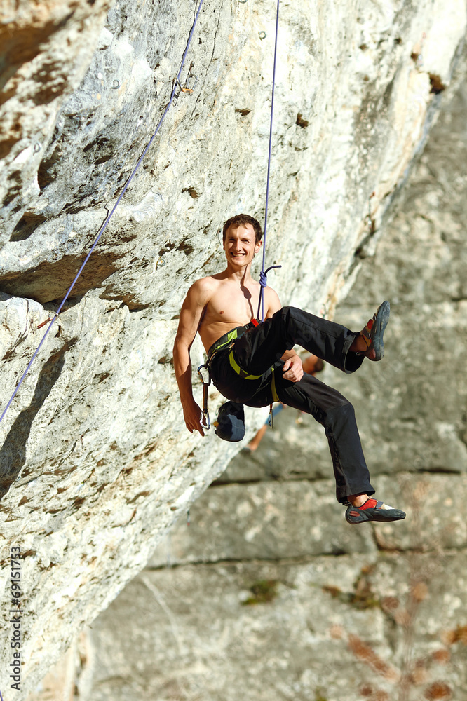 Rock climber climbing up a cliff Rock climber climbing up a cliff