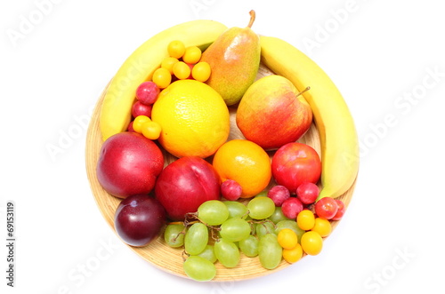 Fresh ripe fruits on wooden plate