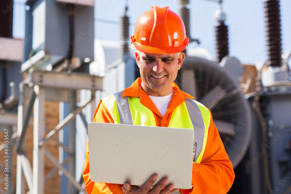 mid age engineer using laptop computer in power plant mid age engineer using laptop computer in power plant