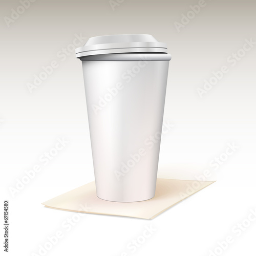 Paper cup for coffee standing on a napkin.