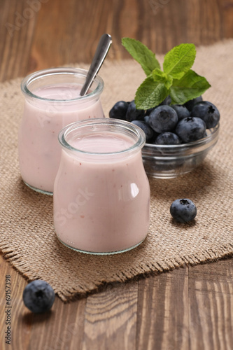 yogurt with blueberries in a glass jar and blueberries in a glas