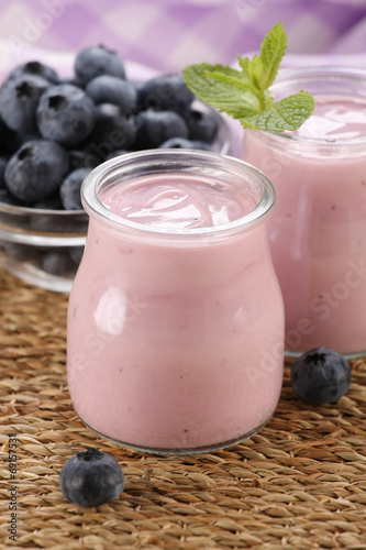 yogurt with blueberries in a glass jar and blueberries in a glas