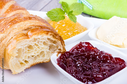 Croissant zum Frühstück mit Marmelade und Butter