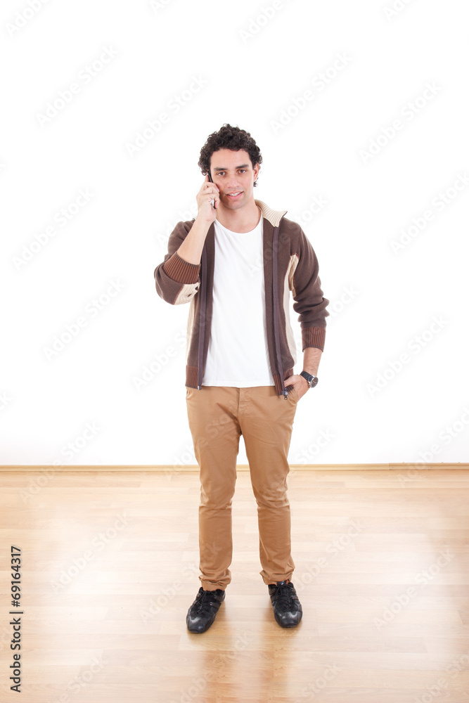 Full length portrait of handsome young man talking over phone