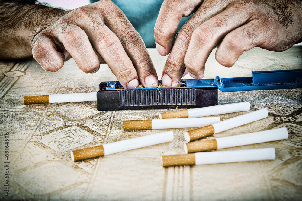 Hands of man making cigarettes Hands of man making cigarettes