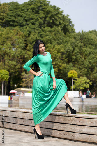 Beautiful young woman in green long dress