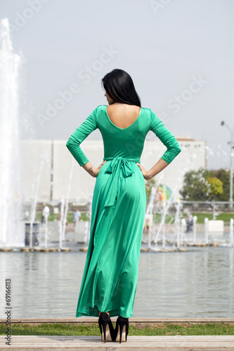 Beautiful young woman in green long dress © Andrey_Arkusha