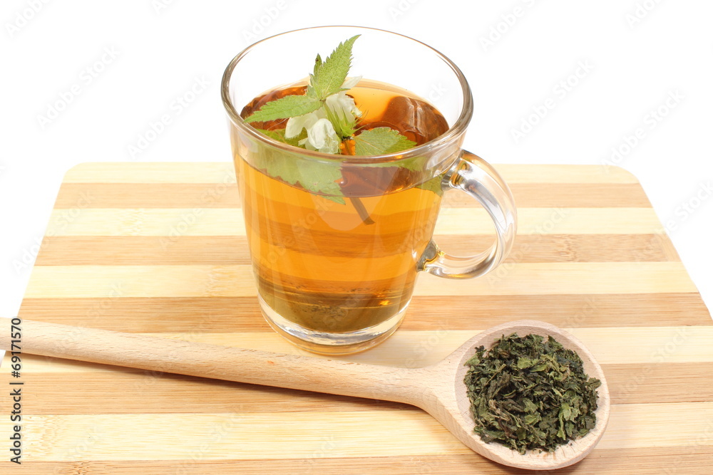Fresh and dried nettle with cup of beverage Fresh and dried nettle with cup of beverage