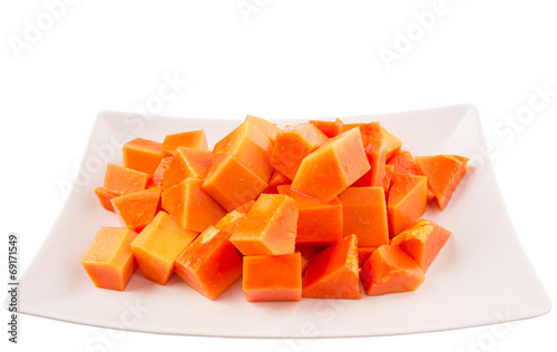 Bite sized papaya fruit on white plate over white background