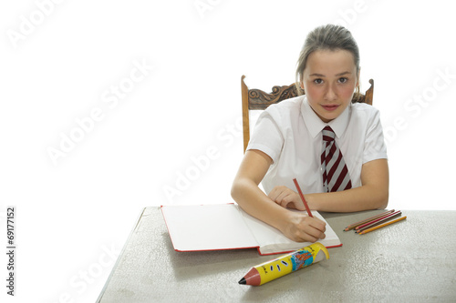 Young schoolgirl sitting doing her homework photo